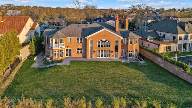 back of house featuring french doors, a patio, a chimney, and a yard