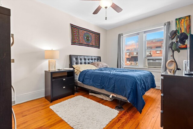 bedroom with baseboards, light wood-style flooring, and a ceiling fan