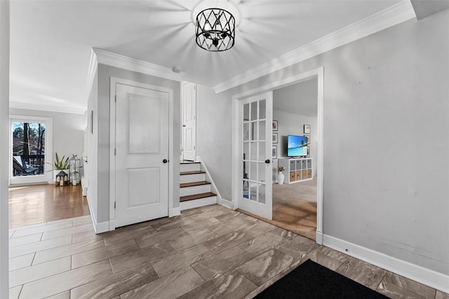 entrance foyer featuring french doors, ornamental molding, baseboards, and an inviting chandelier