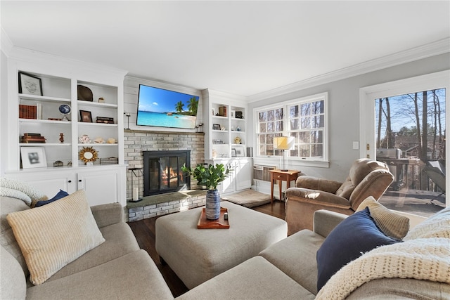 living area featuring a brick fireplace, built in features, ornamental molding, and wood finished floors