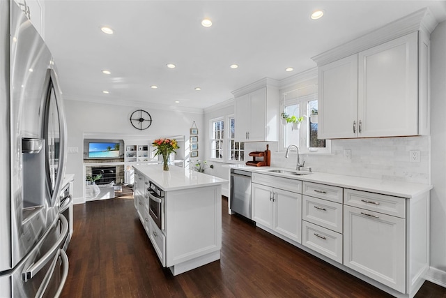 kitchen featuring light countertops, stainless steel appliances, white cabinetry, and a sink