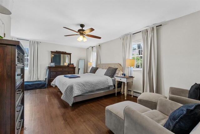 bedroom with dark wood-style flooring, ceiling fan, multiple windows, and a baseboard radiator