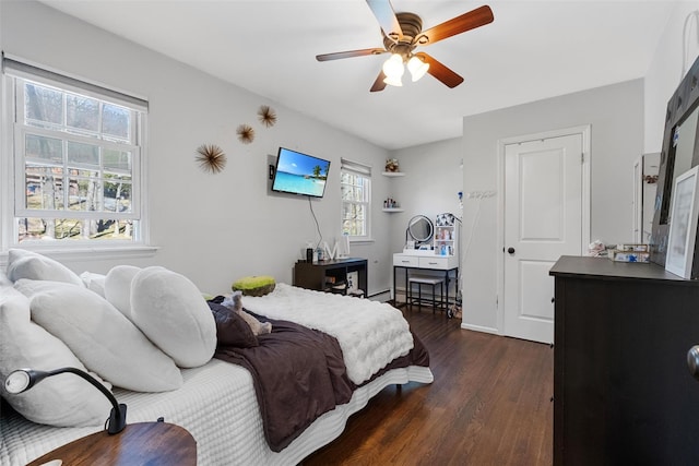 bedroom featuring a ceiling fan, a baseboard heating unit, and dark wood-type flooring
