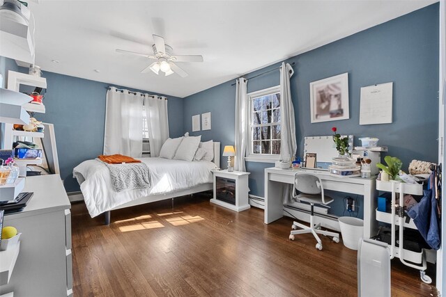 bedroom with a baseboard radiator, ceiling fan, and wood finished floors