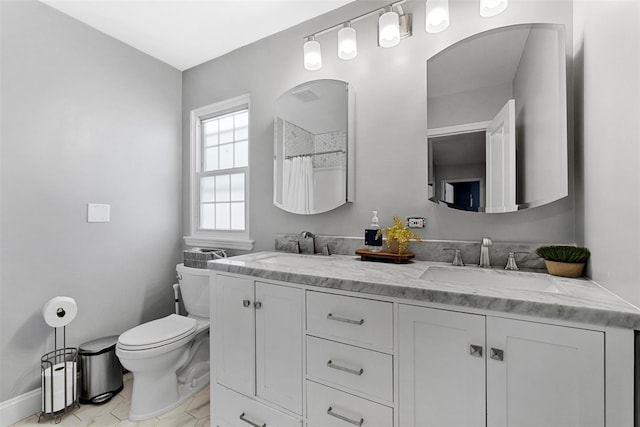 full bath with baseboards, a sink, double vanity, and toilet