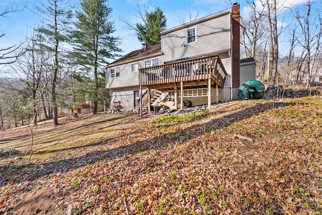 rear view of house with a deck, a chimney, and stairs
