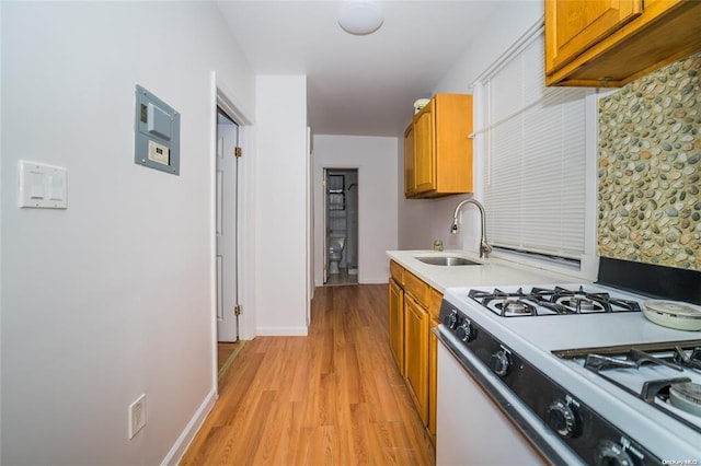 3440 Fulton St, Brooklyn, NY 11208 - kitchen with white gas stove, brown cabinetry, light countertops, and a sink