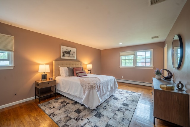 10 Hickory Ln, Glen Cove, NY 11542 - bedroom featuring a baseboard radiator, wood finished floors, baseboards, and recessed lighting