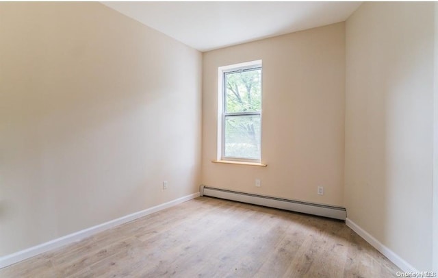 unfurnished room with baseboards, baseboard heating, and light wood-style flooring