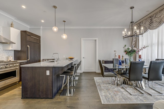 100 Garvies Point Rd Unit 1237, Glen Cove, NY 11542 - kitchen featuring high end range, a breakfast bar, ornamental molding, a chandelier, and a sink