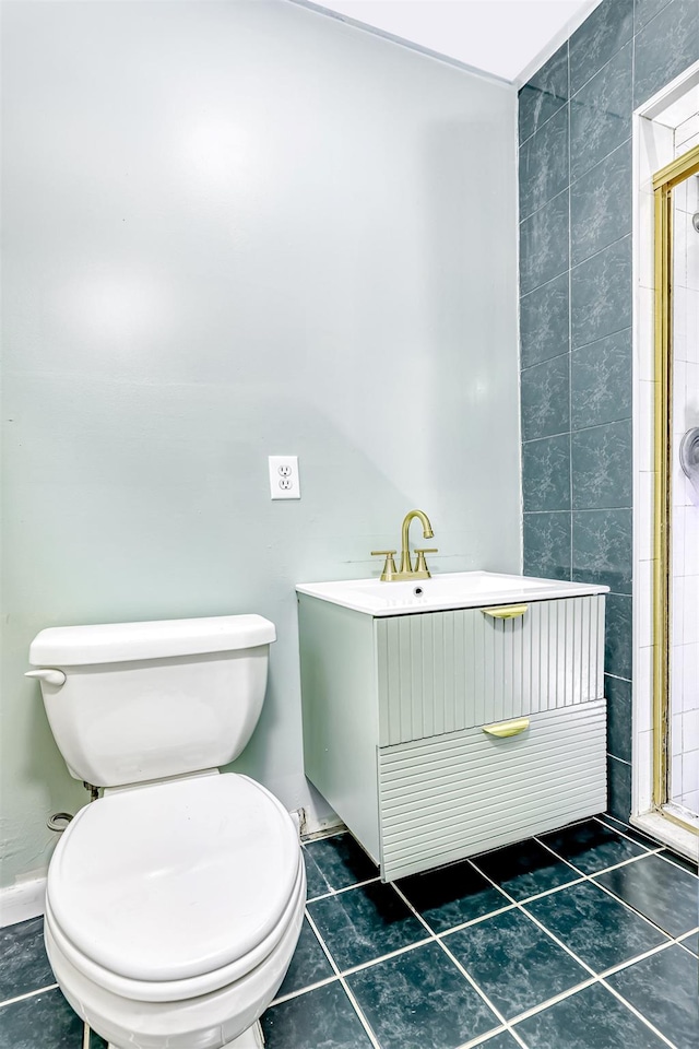 full bath with vanity, tile walls, toilet, tile patterned floors, and a stall shower