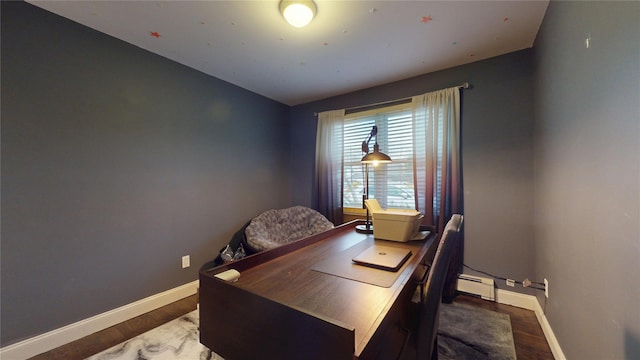 office with a baseboard heating unit, baseboards, and wood finished floors