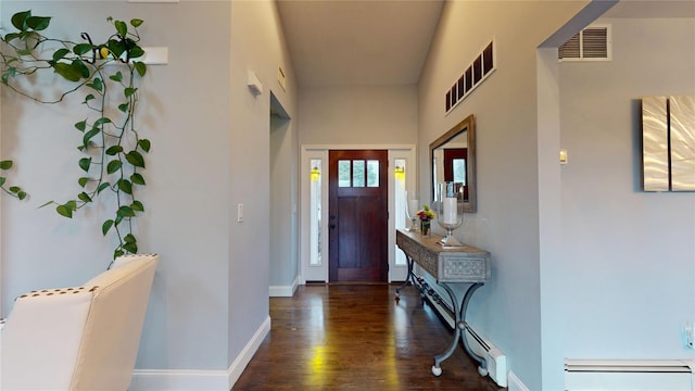 foyer entrance with wood finished floors, baseboards, baseboard heating, and visible vents