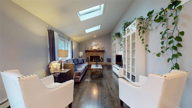 living area featuring baseboard heating, lofted ceiling with skylight, dark wood-style floors, and a fireplace
