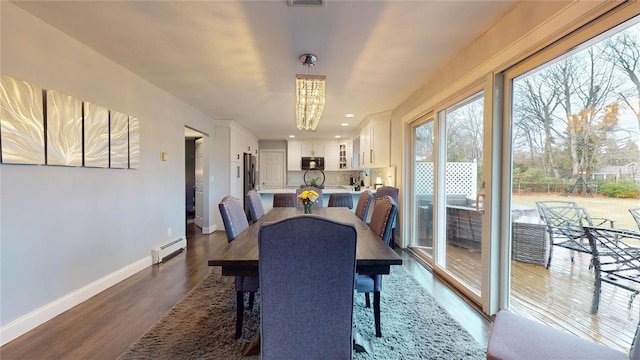 dining space featuring dark wood finished floors, visible vents, baseboards, a notable chandelier, and baseboard heating