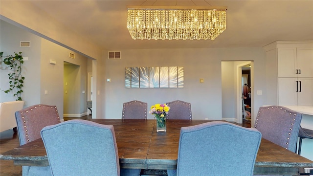 dining area featuring visible vents, baseboards, and an inviting chandelier