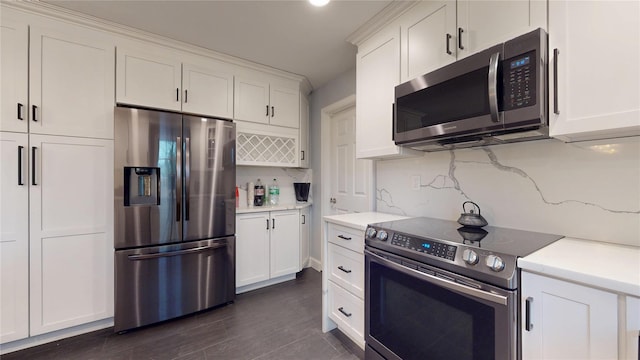 kitchen featuring white cabinets, decorative backsplash, appliances with stainless steel finishes, and dark wood-type flooring