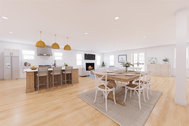 62 Rochester Ave, Long Beach, NY 11561 - dining room with a lit fireplace, recessed lighting, and light wood-type flooring