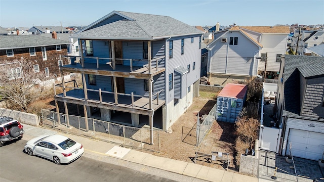62 Rochester Ave, Long Beach, NY 11561 - rear view of house with fence, roof with shingles, and a residential view