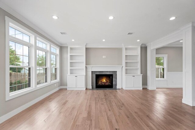 407 Wellington Rd, East Meadow, NY 11554 - unfurnished living room featuring light wood-style flooring, a fireplace with flush hearth, recessed lighting, crown molding, and built in features