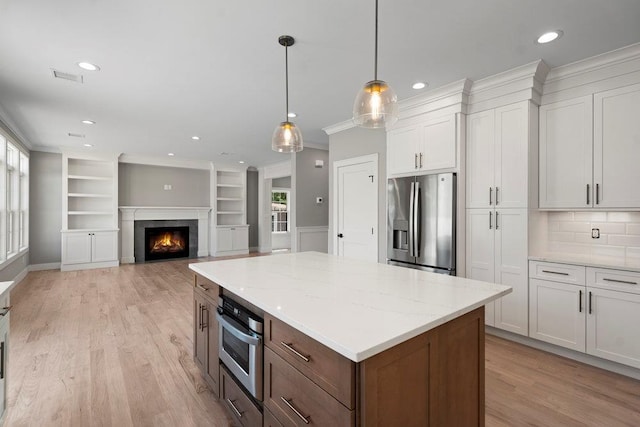 407 Wellington Rd, East Meadow, NY 11554 - kitchen featuring appliances with stainless steel finishes, plenty of natural light, recessed lighting, a center island, and light wood-type flooring