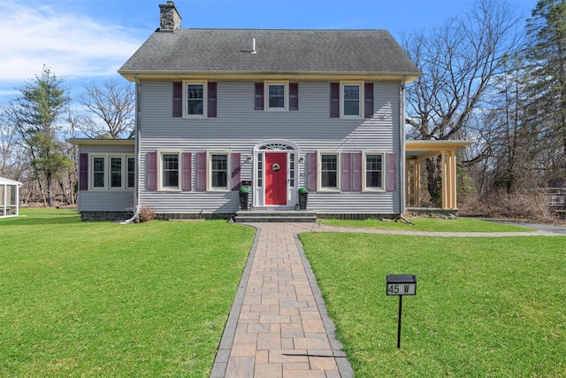 view of front of house with a front lawn and a chimney