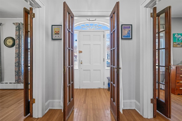 foyer entrance featuring light wood-style floors and french doors