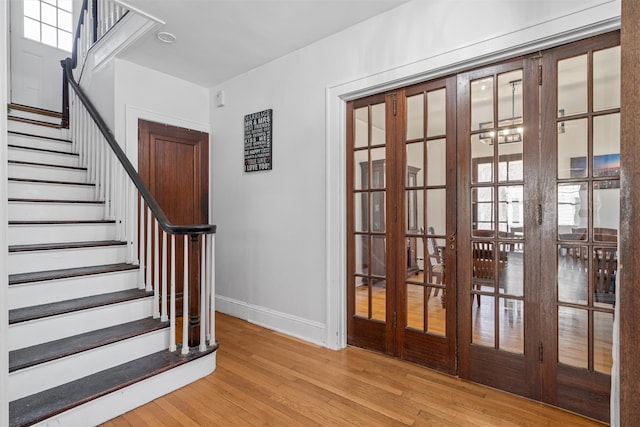 staircase featuring baseboards, french doors, and wood-type flooring