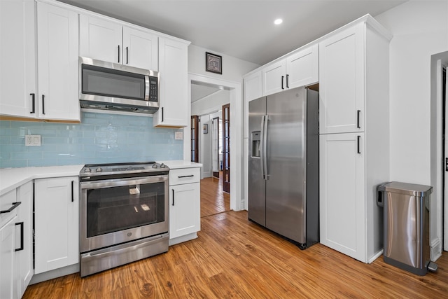 kitchen featuring white cabinets, light countertops, appliances with stainless steel finishes, and light wood finished floors