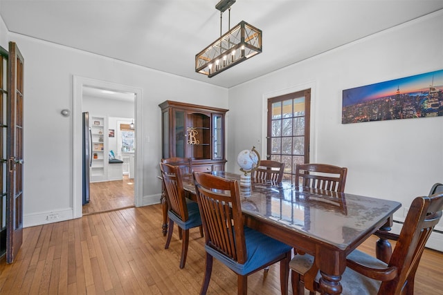 dining room with hardwood / wood-style floors, baseboards, and an inviting chandelier