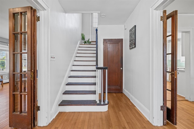 stairway featuring hardwood / wood-style floors, baseboards, and a baseboard heating unit