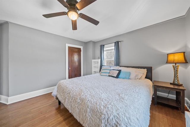 bedroom with baseboards, ceiling fan, and wood finished floors