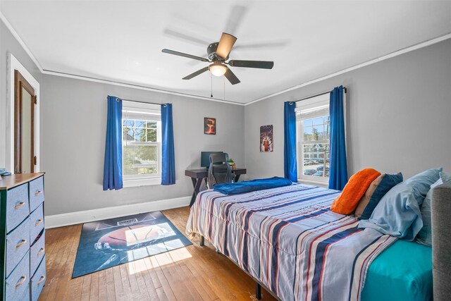 bedroom featuring multiple windows, crown molding, and hardwood / wood-style flooring