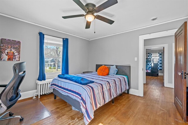 bedroom featuring baseboards, radiator heating unit, and hardwood / wood-style floors