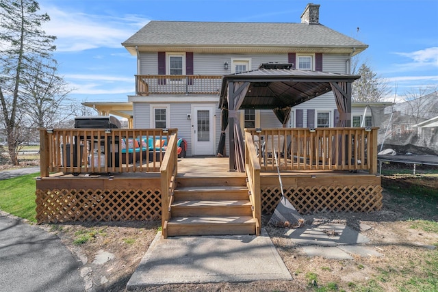 back of property featuring a gazebo and a chimney