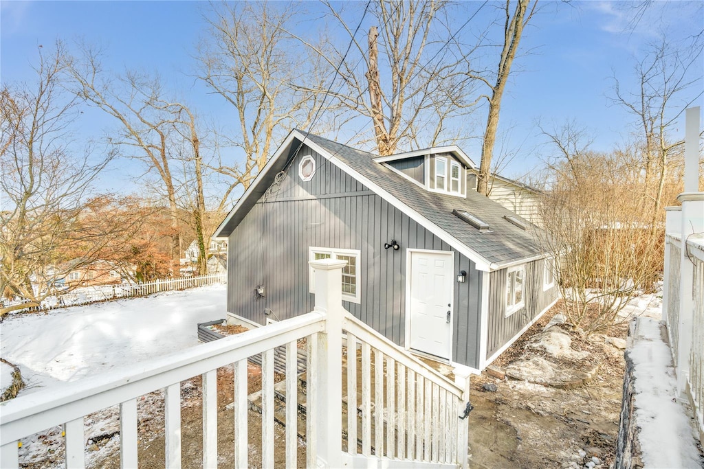 exterior space with roof with shingles and fence