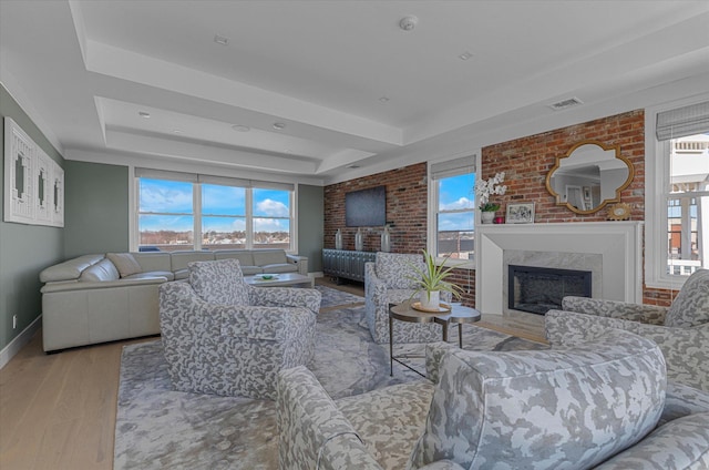 31 Casino St Ph, Ph, Freeport, NY 11520 - living room featuring baseboards, a raised ceiling, visible vents, a fireplace, and wood finished floors