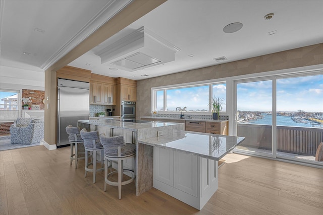 31 Casino St Ph, Ph, Freeport, NY 11520 - kitchen featuring a breakfast bar, a large island, light wood-style flooring, and stainless steel appliances