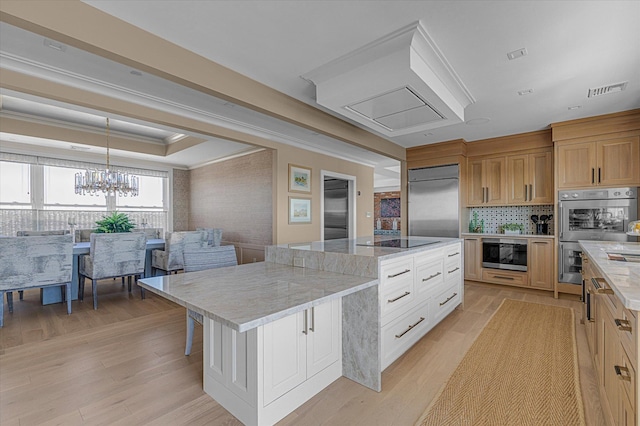 31 Casino St Ph, Ph, Freeport, NY 11520 - kitchen featuring a tray ceiling, built in appliances, a large island, and light wood-type flooring