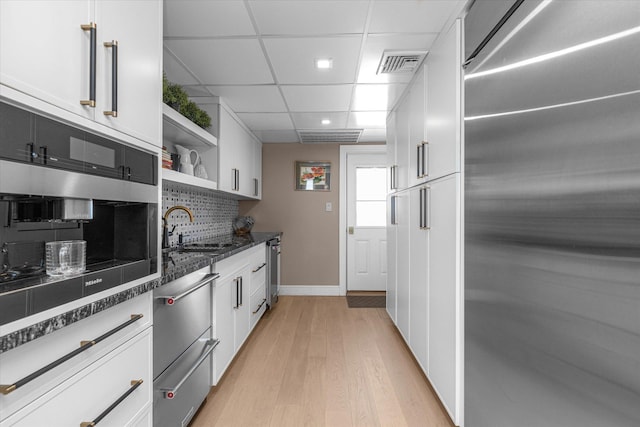 31 Casino St Ph, Ph, Freeport, NY 11520 - kitchen featuring a sink, white cabinetry, a warming drawer, stainless steel appliances, and visible vents