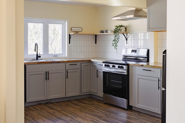 kitchen featuring a sink, gray cabinetry, dark wood-style floors, wall chimney range hood, and stainless steel electric stove