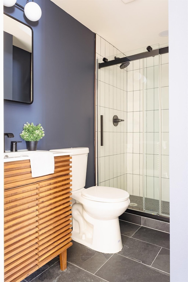 bathroom with a shower stall, toilet, tile patterned flooring, and vanity