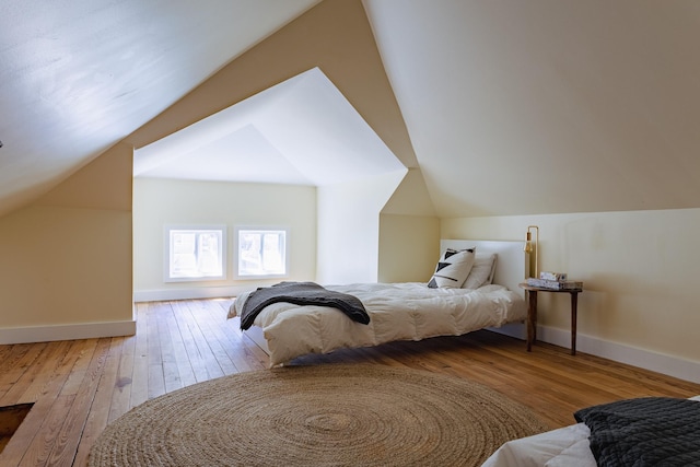 bedroom featuring baseboards, lofted ceiling, and hardwood / wood-style flooring