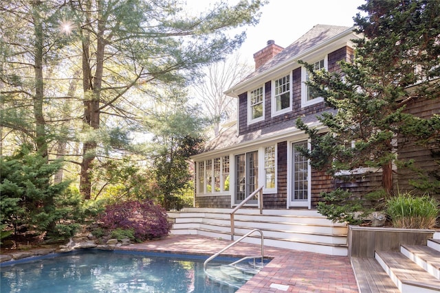 53 Cedar Ln W, Remsenburg, NY 11960 - view of front facade featuring a chimney, an outdoor pool, and roof with shingles