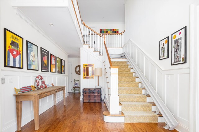 53 Cedar Ln W, Remsenburg, NY 11960 - stairway featuring a decorative wall, crown molding, wood finished floors, and wainscoting