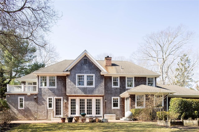 53 Cedar Ln W, Remsenburg, NY 11960 - back of property with a chimney, a yard, roof with shingles, and a patio