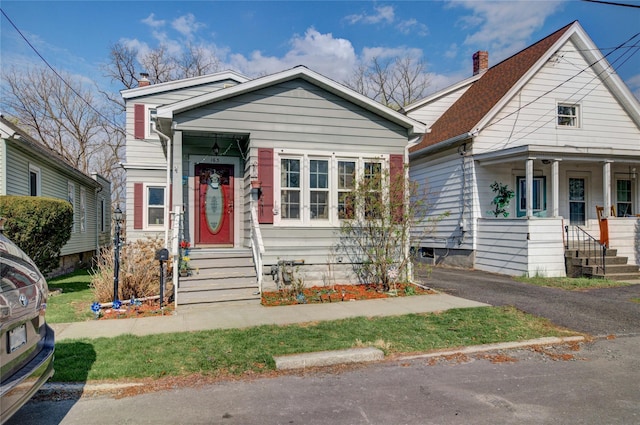 shotgun-style home with a chimney and a porch