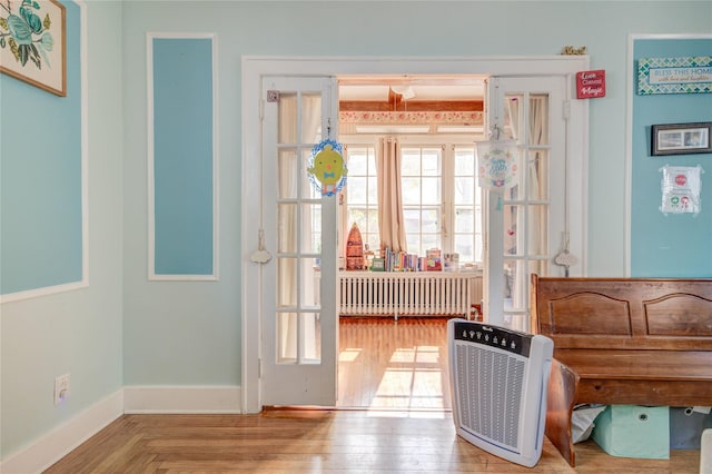 163 Simmons Ave, Call Listing Agent, NY 12047 - doorway to outside with radiator, heating unit, wood finished floors, and baseboards