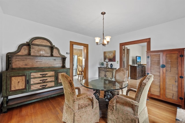 dining area with an inviting chandelier and wood finished floors
