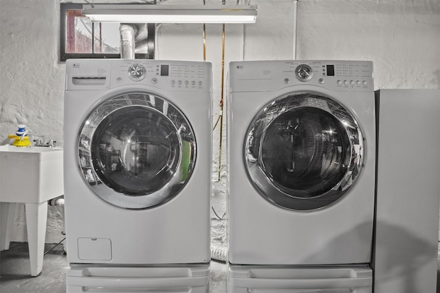 laundry area featuring washer and clothes dryer and a sink